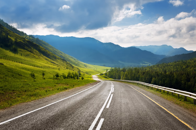 An example of a road: a single lane motorway going through the countryside, located in the US, with no buildings in sight